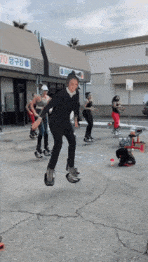 a group of people are jumping in the air in front of a building that says 70 on it