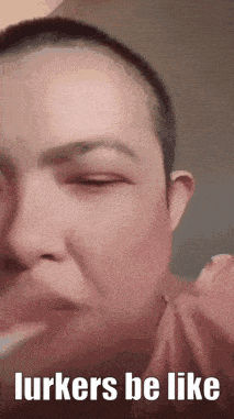 a woman with a shaved head is making a funny face with her eyes closed .