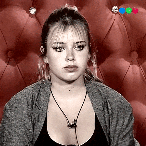 a woman with a necklace around her neck is sitting on a red chair