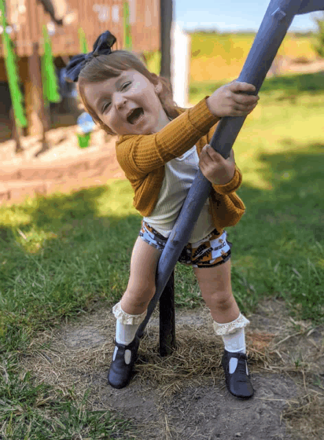 a little girl in shorts and socks is playing on a playground