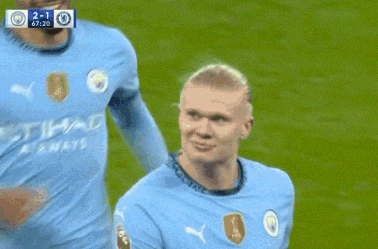 two soccer players are hugging each other on a field and one of them is wearing a shirt that says etihad airways