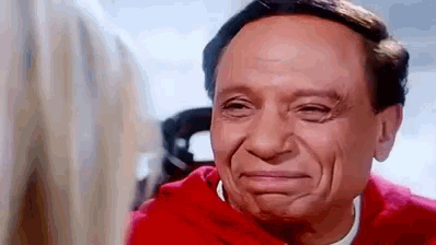 a close up of a man making a funny face while looking at a woman .