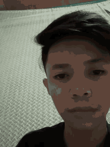a close up of a person 's face with a patterned blanket in the background