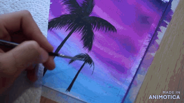 a person is painting palm trees with a brush on a piece of paper that says made in animotica