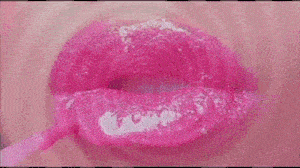 a close up of a woman 's lips with pink lipstick and a swirl in the background .