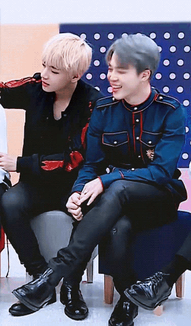 two men are sitting next to each other and one of them is wearing a blue jacket