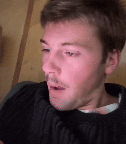 a close up of a man 's face with a sweater on