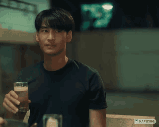 a man in a black shirt is holding a glass of beer and says who the heck invited you here