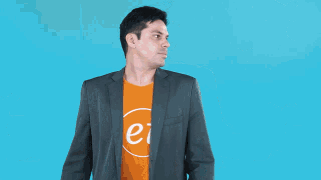a man wearing an orange shirt that says " ei " is surrounded by question marks