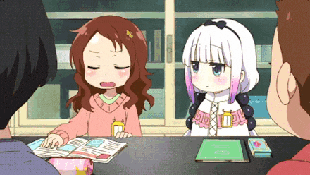 a group of anime characters are sitting around a table with a book .