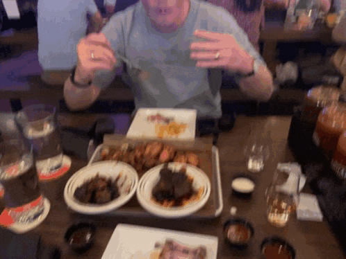 a man sitting at a table with plates of food