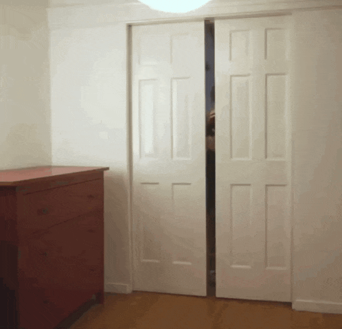 a red dresser sits in a room with sliding doors