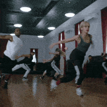 a group of people are doing exercises in a gym