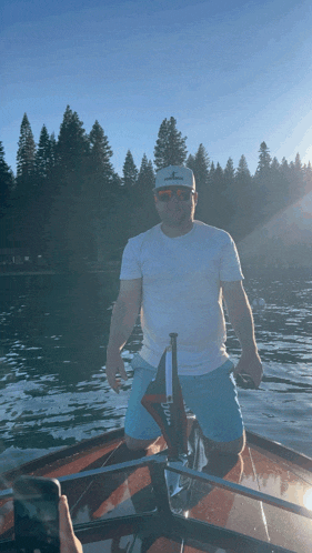 a man on a boat wearing a white shirt that says california