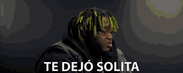 a man with green hair says te dejo solita in white letters
