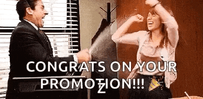 a man and a woman are standing next to each other in an office . the man is congratulating the woman on her promotion .
