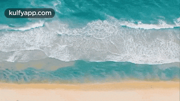 an aerial view of a beach with waves crashing against it