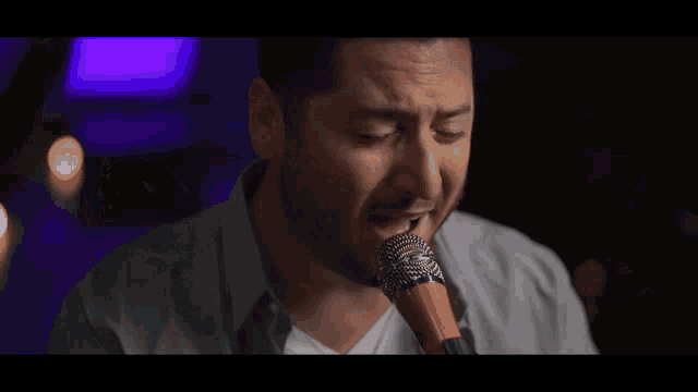 a man singing into a microphone with a beard