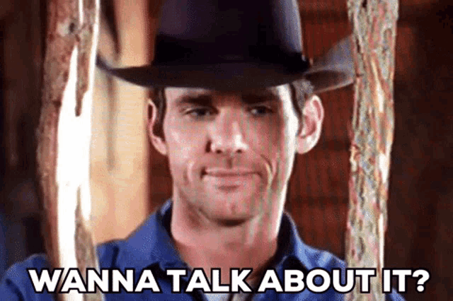 a man wearing a cowboy hat is asking wanna talk about it