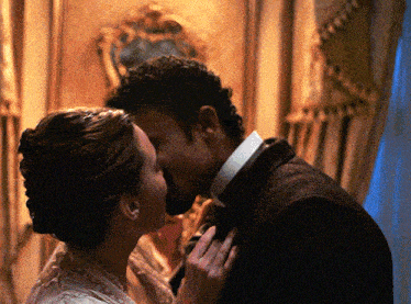 a man and woman kiss in front of a painting