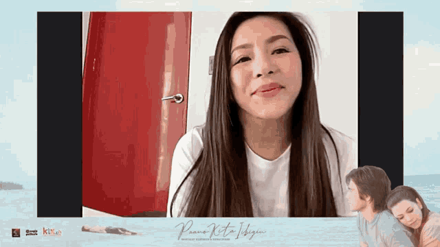 a woman with long hair is smiling in front of a red door and a picture of a man and a woman