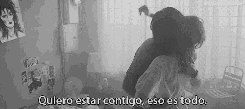 a black and white photo of two people hugging with the caption quiero estar contigo