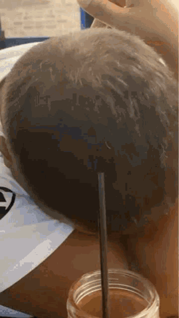 a person is drinking from a glass with a straw