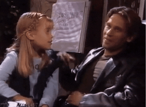 a man and a little girl are sitting next to each other in front of a sign that says ' costume ' on it