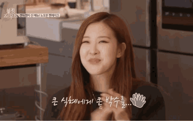 a woman making a funny face in front of a refrigerator with korean writing on it