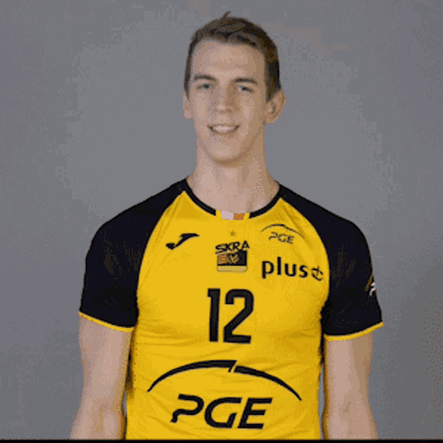 a young man wearing a yellow and black pge shirt