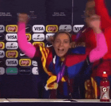 a group of people are celebrating with a bottle of gatorade in the background
