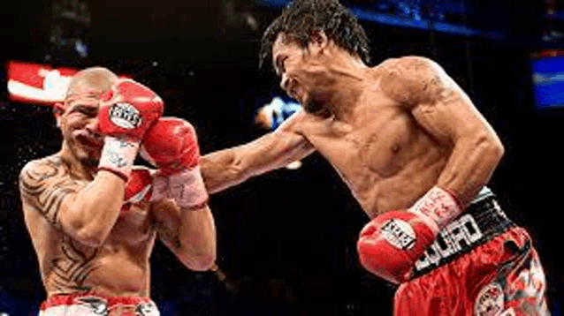 two men are boxing in a ring .