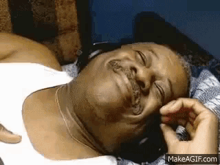 a man wearing headphones is laying down and smiling