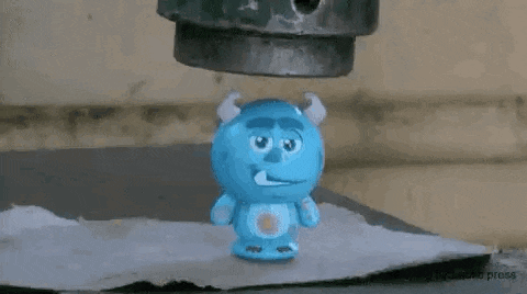 a blue monster from monsters inc is being pressed by a machine .