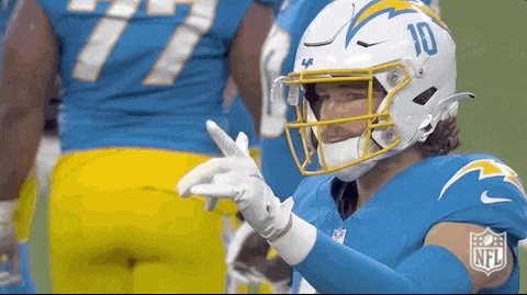 a football player wearing a helmet and gloves is giving a thumbs up .