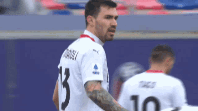 a man with a tattoo on his arm is wearing a jersey with the number 13 on it