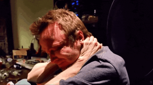 a close up of a person holding a man 's neck in a dark room