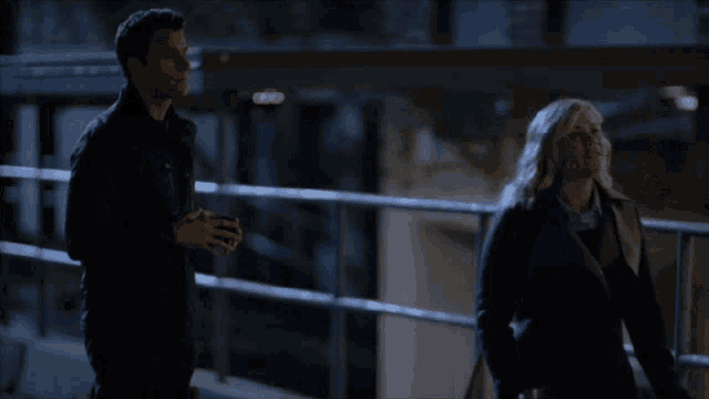a man and a woman are standing next to each other in a dark room