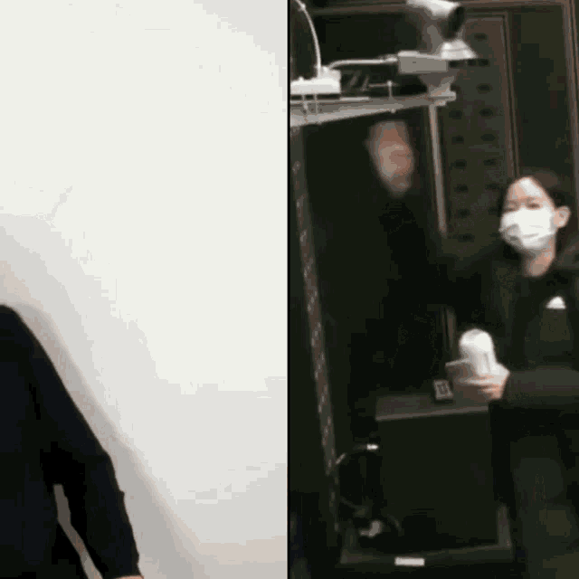 a woman wearing a mask is standing next to a mirror