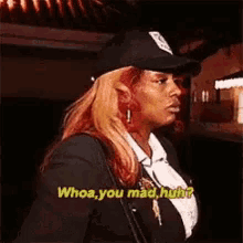 a woman wearing a hat and a suit says whoa you mad huh .