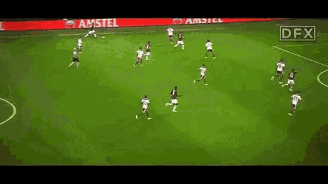 a group of soccer players are playing on a field with an amstel ad behind them