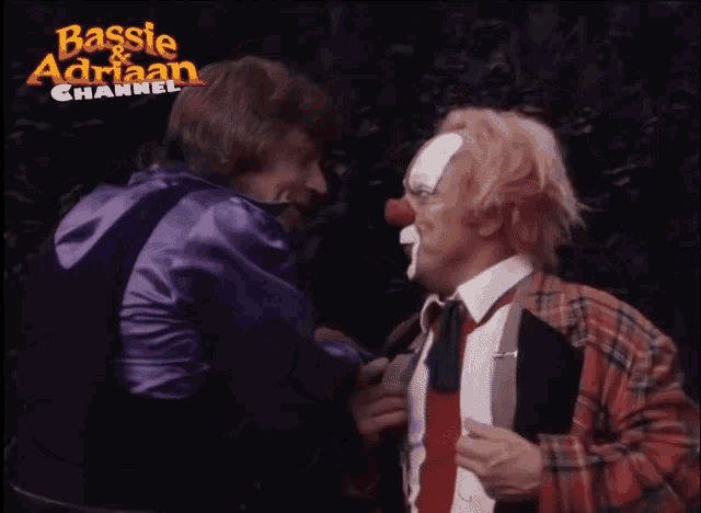 a clown with a red nose is talking to a man in a purple jacket
