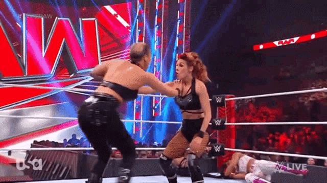 two female wrestlers are fighting in a ring .