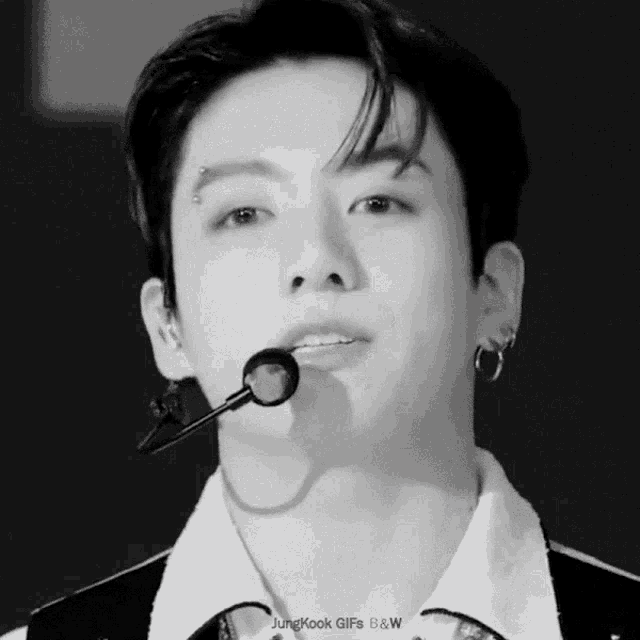 a close up of a man 's face with the words jungkook gifs b & w on the bottom right