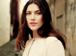 a woman in a white dress is walking down a street