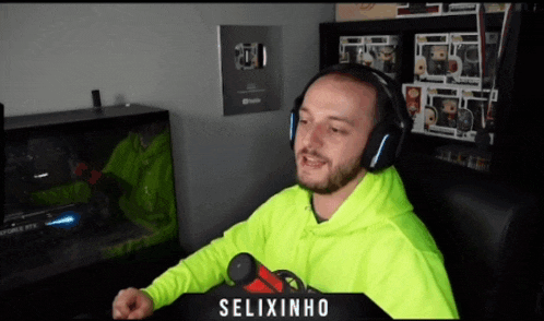 a man wearing headphones and a neon green hoodie is sitting in front of a microphone with the name selixinho on the top