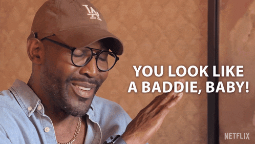 a man wearing a la hat and glasses says " you look like a baddie baby "