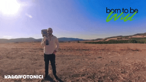 a man standing in a field with the words born to be wild on the top