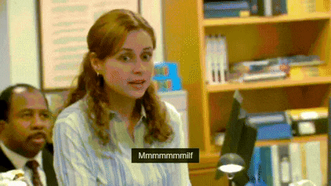 a woman in a striped shirt is sitting in front of a man in a suit and tie ..