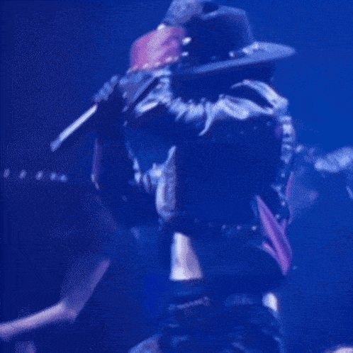 a man in a cowboy hat and a blue jacket is dancing